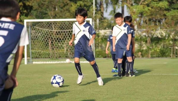 BASIS International School Bangkok students playing football on the outdoor field