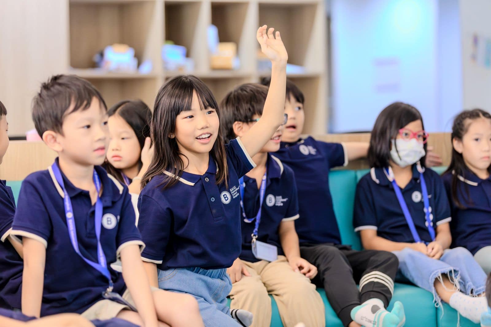 Group of students in class with their hands up
