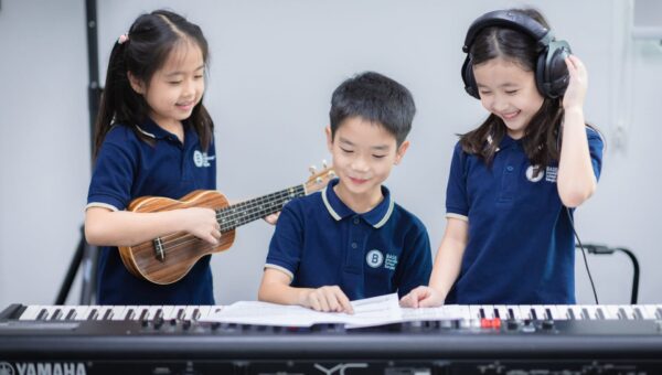 BASIS International School Bangkok students playing keyboard and ukulele together from sheet music