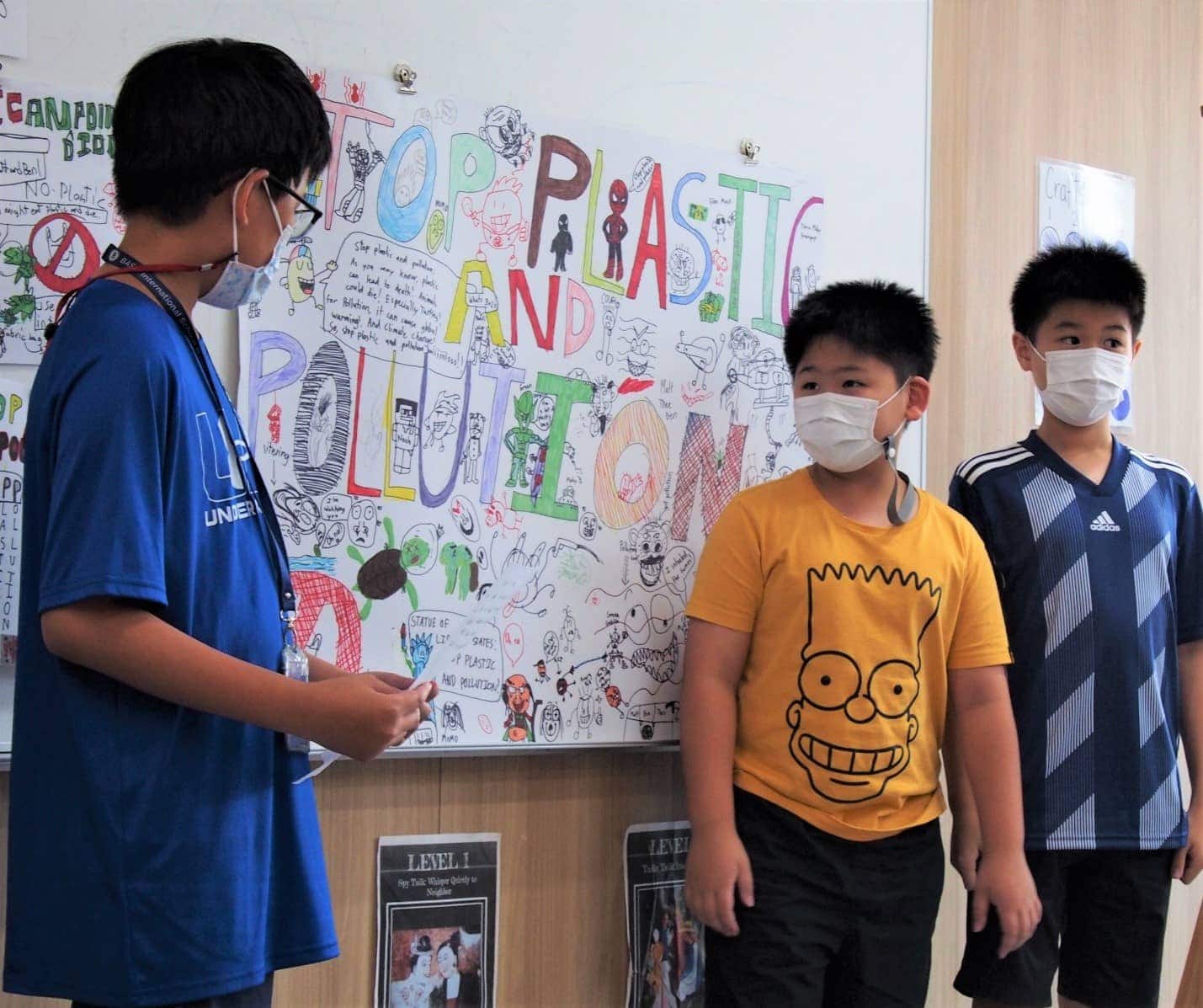 BASIS International School Bangkok students in front of a display of their artwork